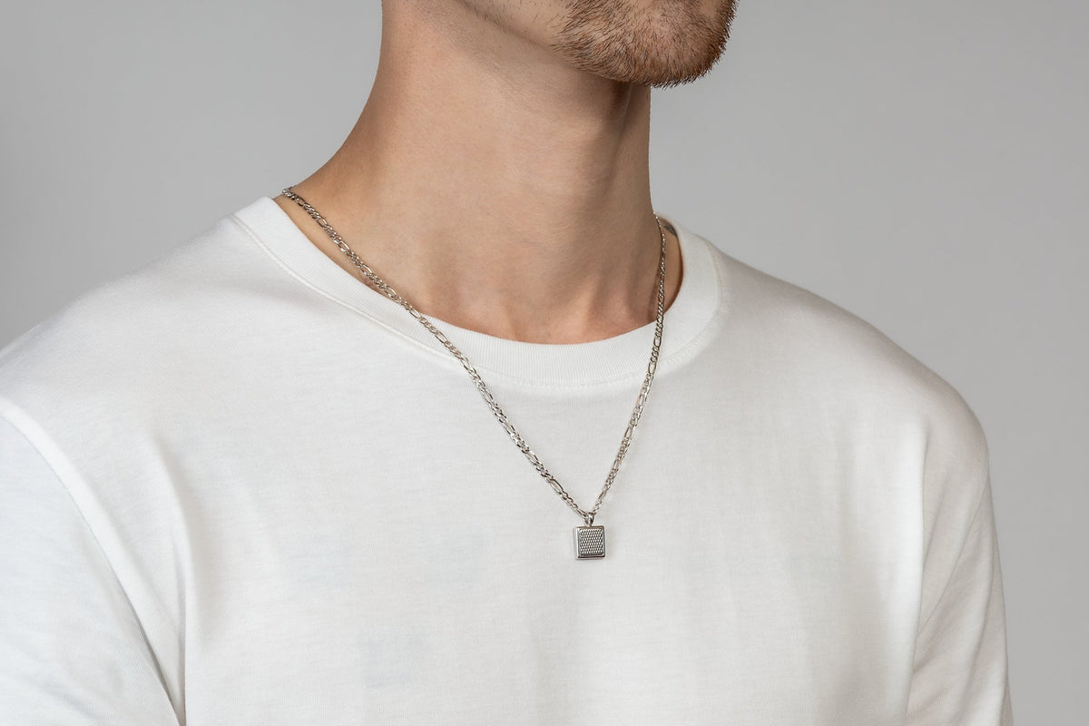 Model wearing a silver Figaro chain with pendant