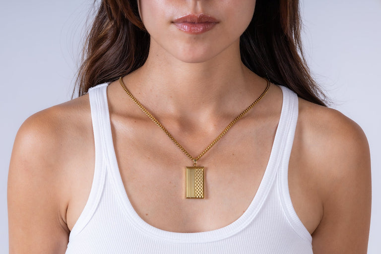Man wearing a gold pendant necklace with a suit